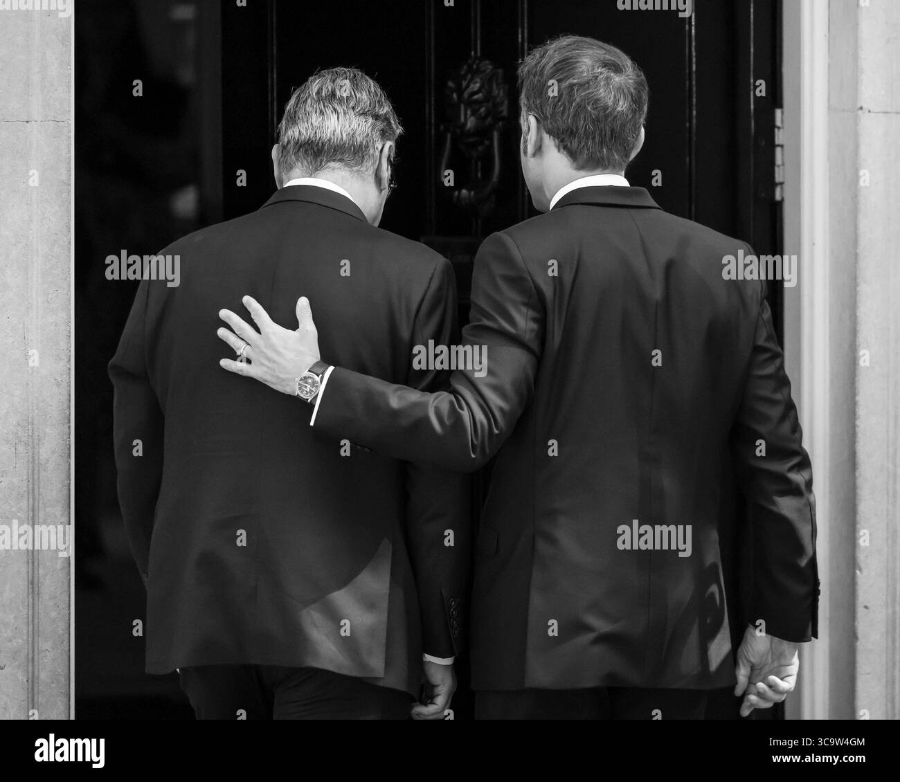 Sir Keir Starmer, primo ministro britannico, e il presidente francese Emmanuel Macron, entrano al numero 10 di Downing Street Together, Londra, monocromatico Foto Stock