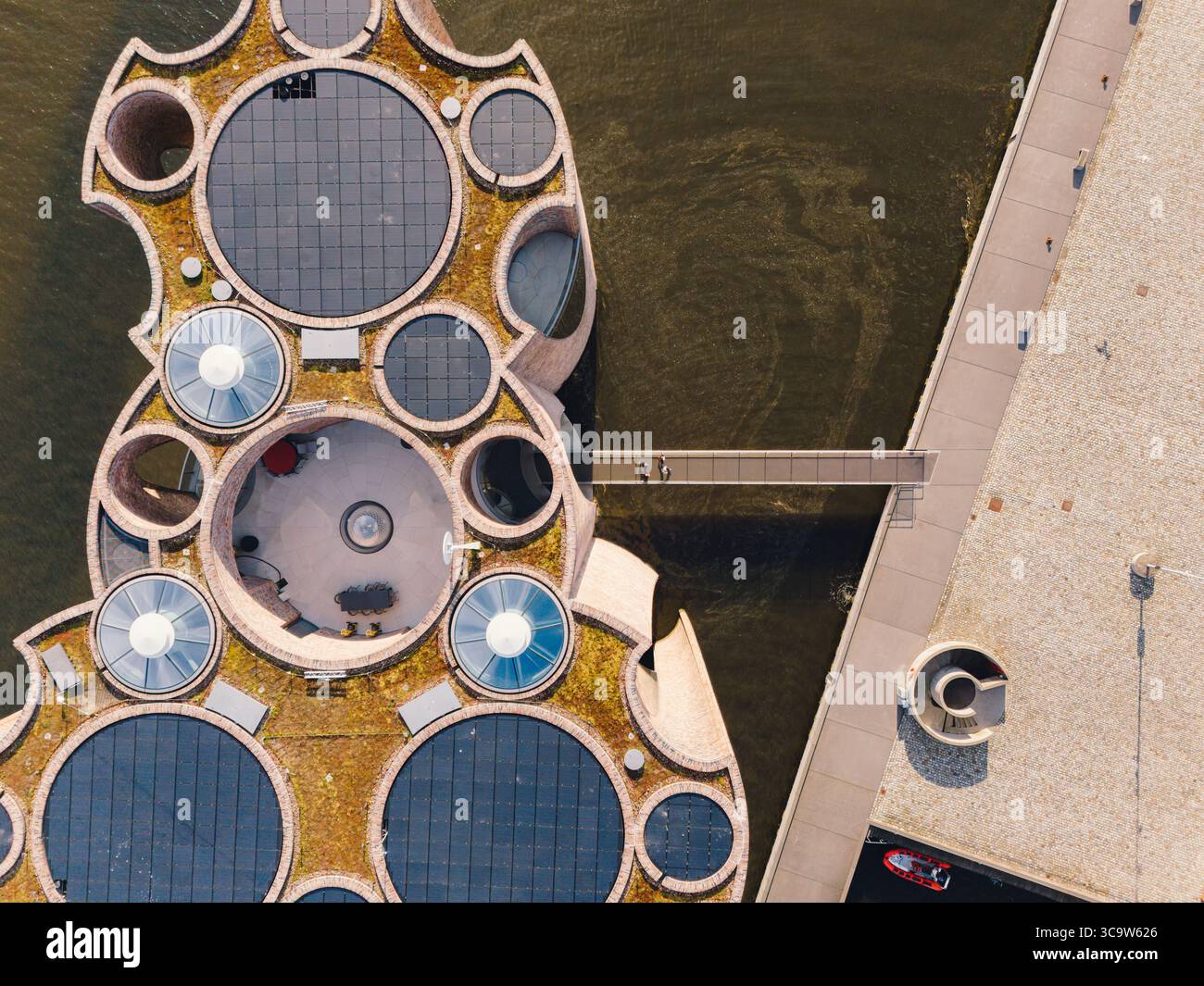 Vista aerea dell'edificio Fjordenhus, una meraviglia architettonica moderna con finestre circolari e design unico, contrasta con l'adiacente passaggio pedonale, Vejle, Danimarca. Foto Stock
