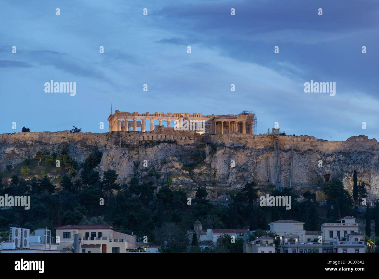L'Acropoli è illuminata dalla luce della sera e immersa nell'illuminazione della città Foto Stock