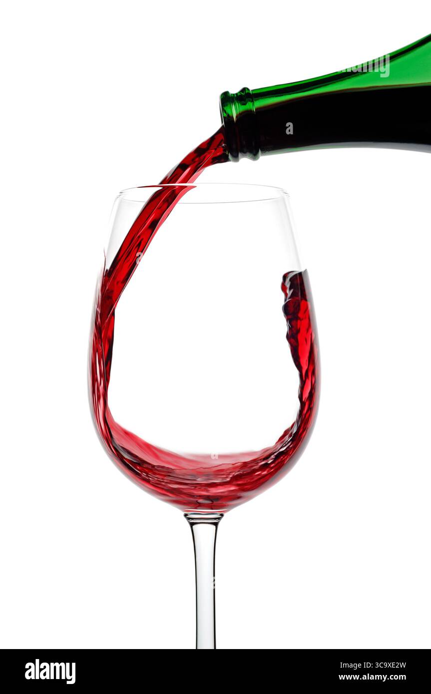 Vino rosso versato in un bicchiere su sfondo bianco, primo piano Foto Stock