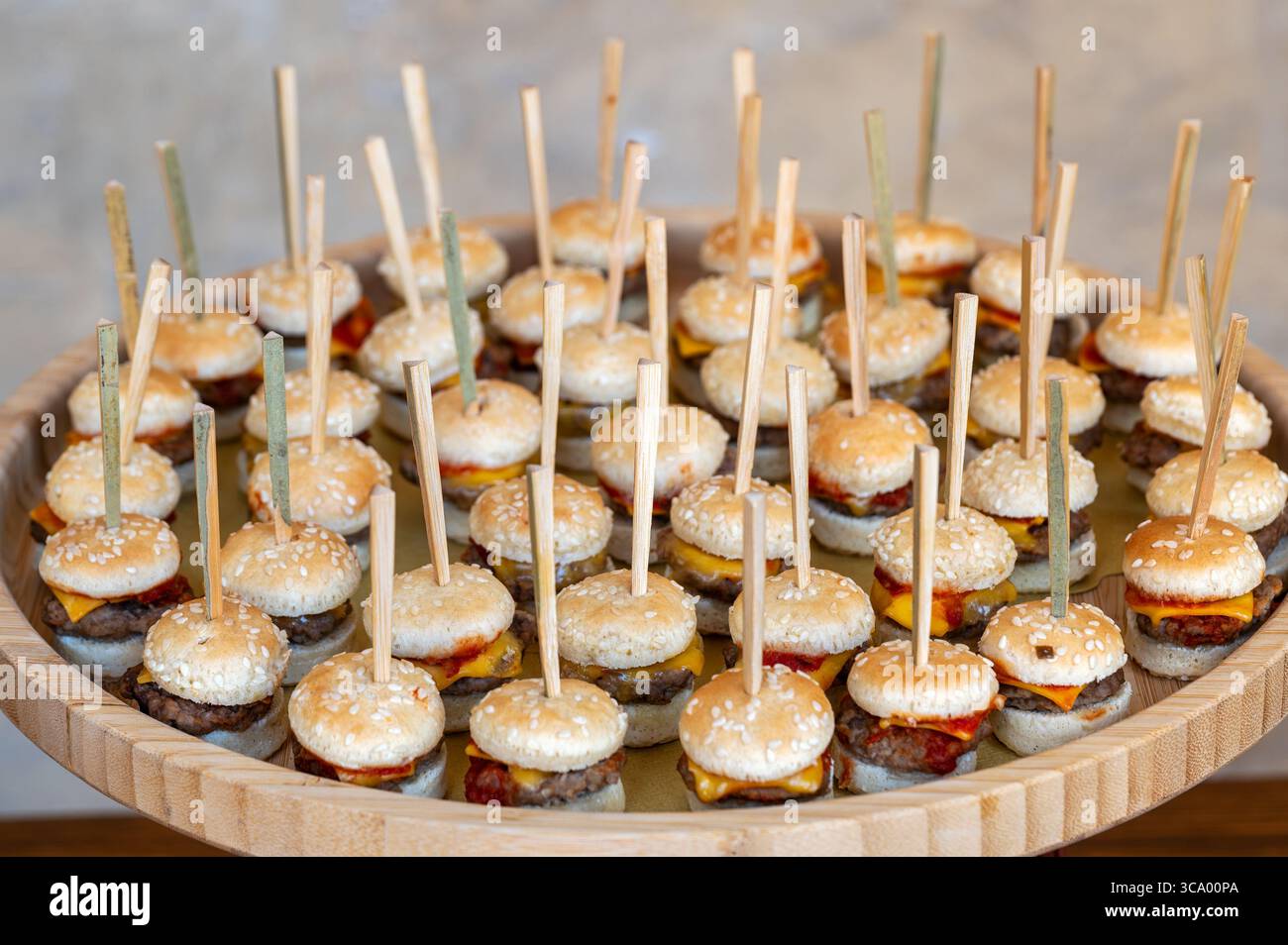 Mini hamburger con ketchup e formaggio serviti come finger food durante un evento di catering Foto Stock