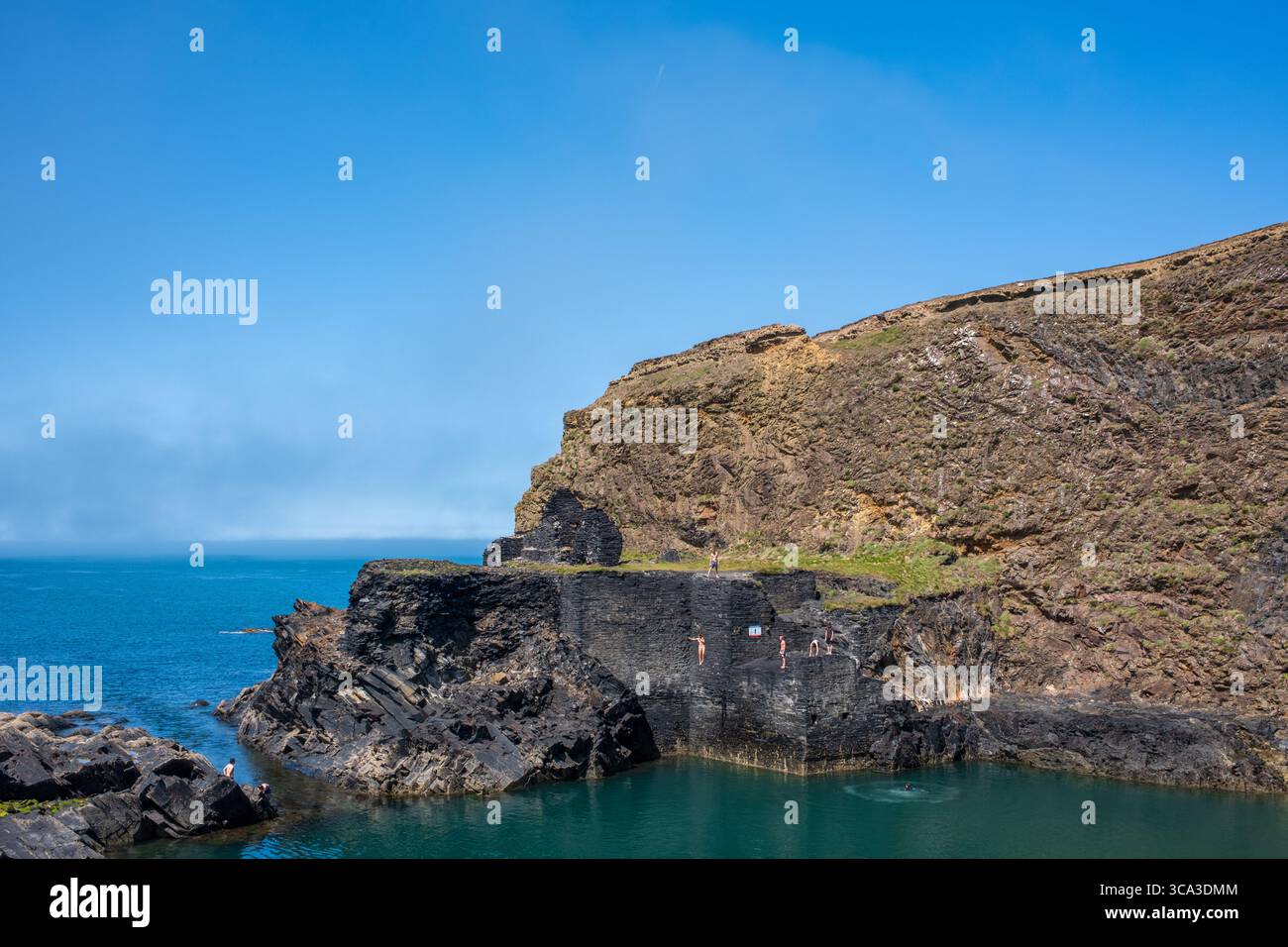 Giovane donna che salta nella Laguna Blu di Abereiddy, Pembrokeshire, Galles occidentale, Regno Unito Foto Stock