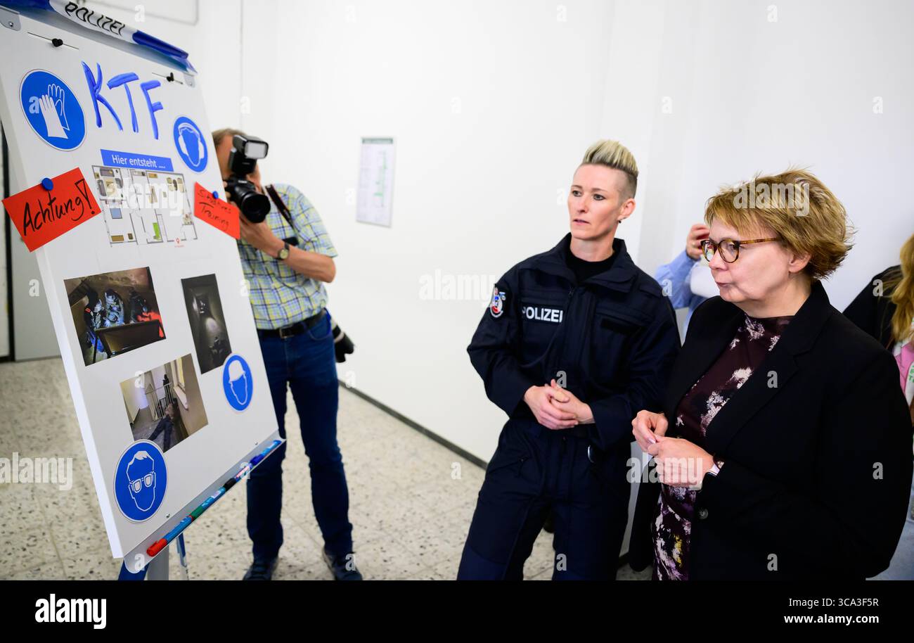 6 agosto 2025, bassa Sassonia, Lüneburg: Daniela Behrens (r, SPD), ministro degli interni della bassa Sassonia, viene mostrata un'aula di addestramento da un addestratore di polizia. Foto: Philipp Schulze/dpa Foto Stock