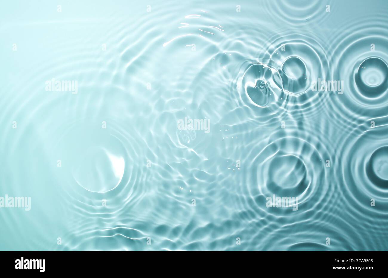 Diverse gocce d'acqua colpiscono la superficie dell'acqua contemporaneamente. Foto Stock