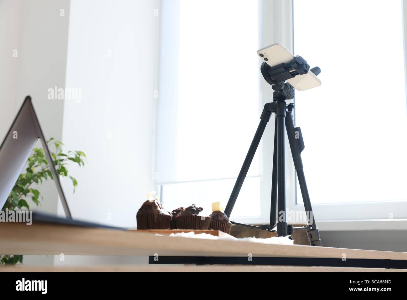 Scatto di muffin al cioccolato con lo smartphone in studio, visuale ad angolo basso. Fotografia gastronomica professionale Foto Stock