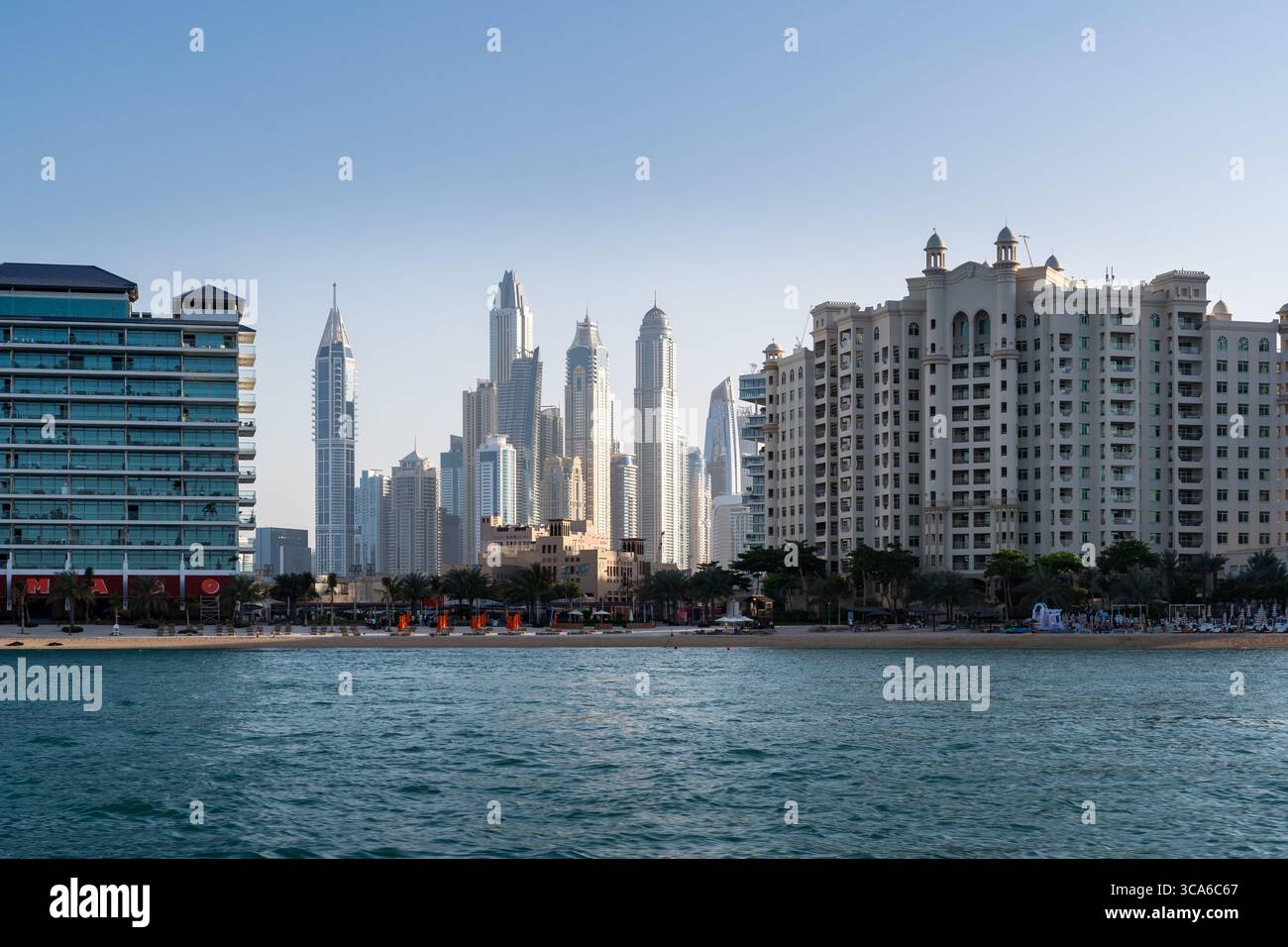 Dubai, Emirati Arabi Uniti - 17 marzo 2023: Complessi residenziali e hotel sulla spiaggia di Dubai visti dalla barca durante una giornata di sole Foto Stock