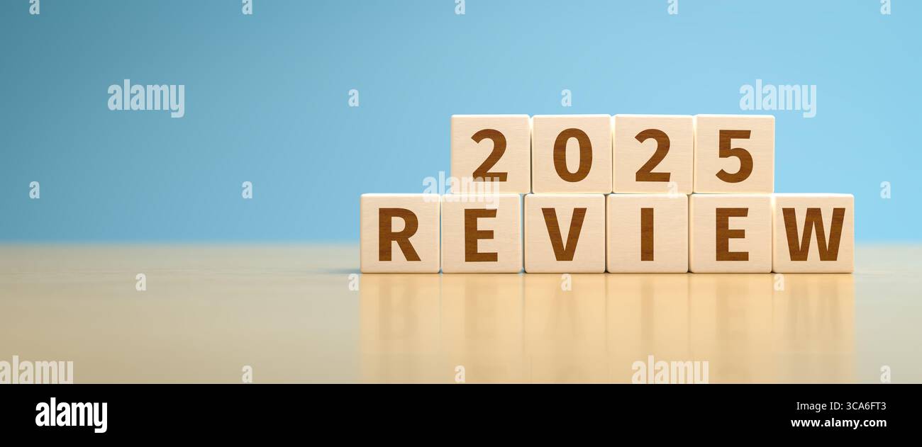 Cubi di giocattoli in legno che formano il testo "REVISIONE 2025". Concetto per rivedere ciò che è successo nell'anno 2025. Foto Stock