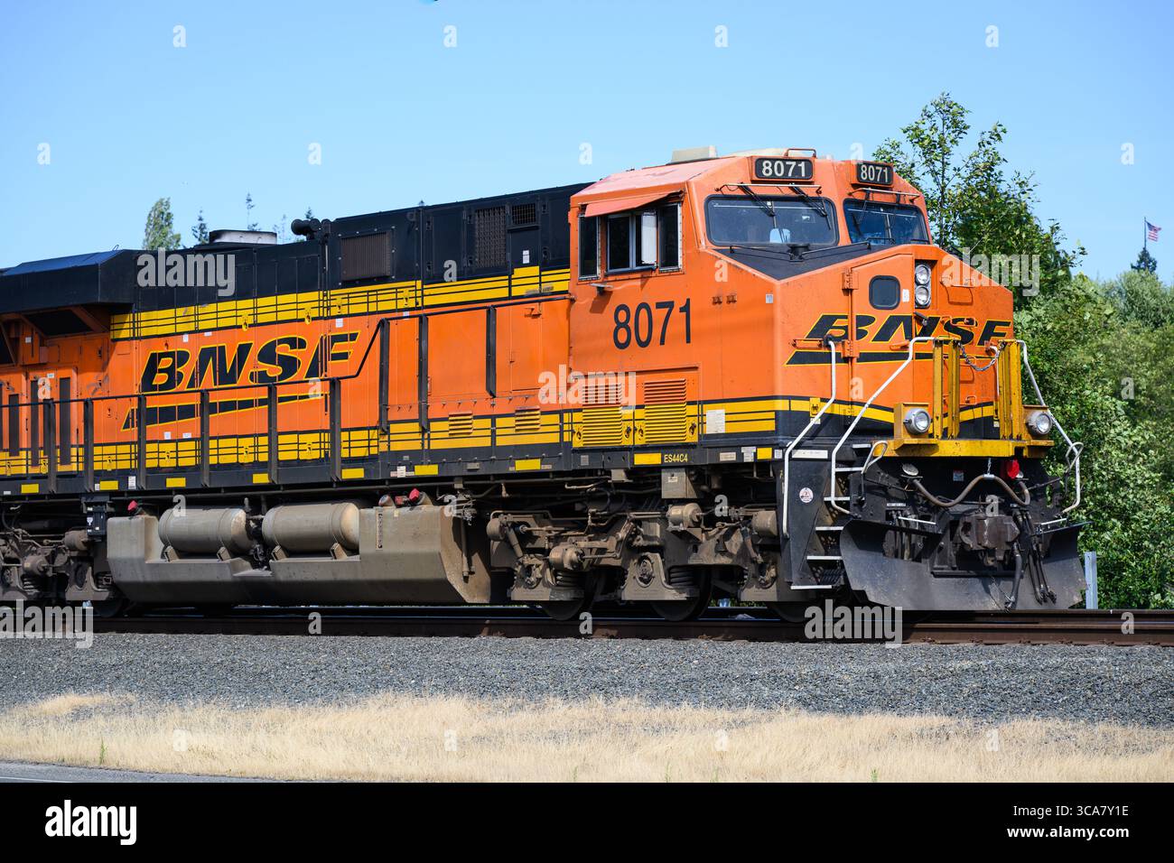 Everett, WA, USA - 30 luglio 2025 - locomotiva merci arancione BNSF in primo piano con logo Swoosh Foto Stock