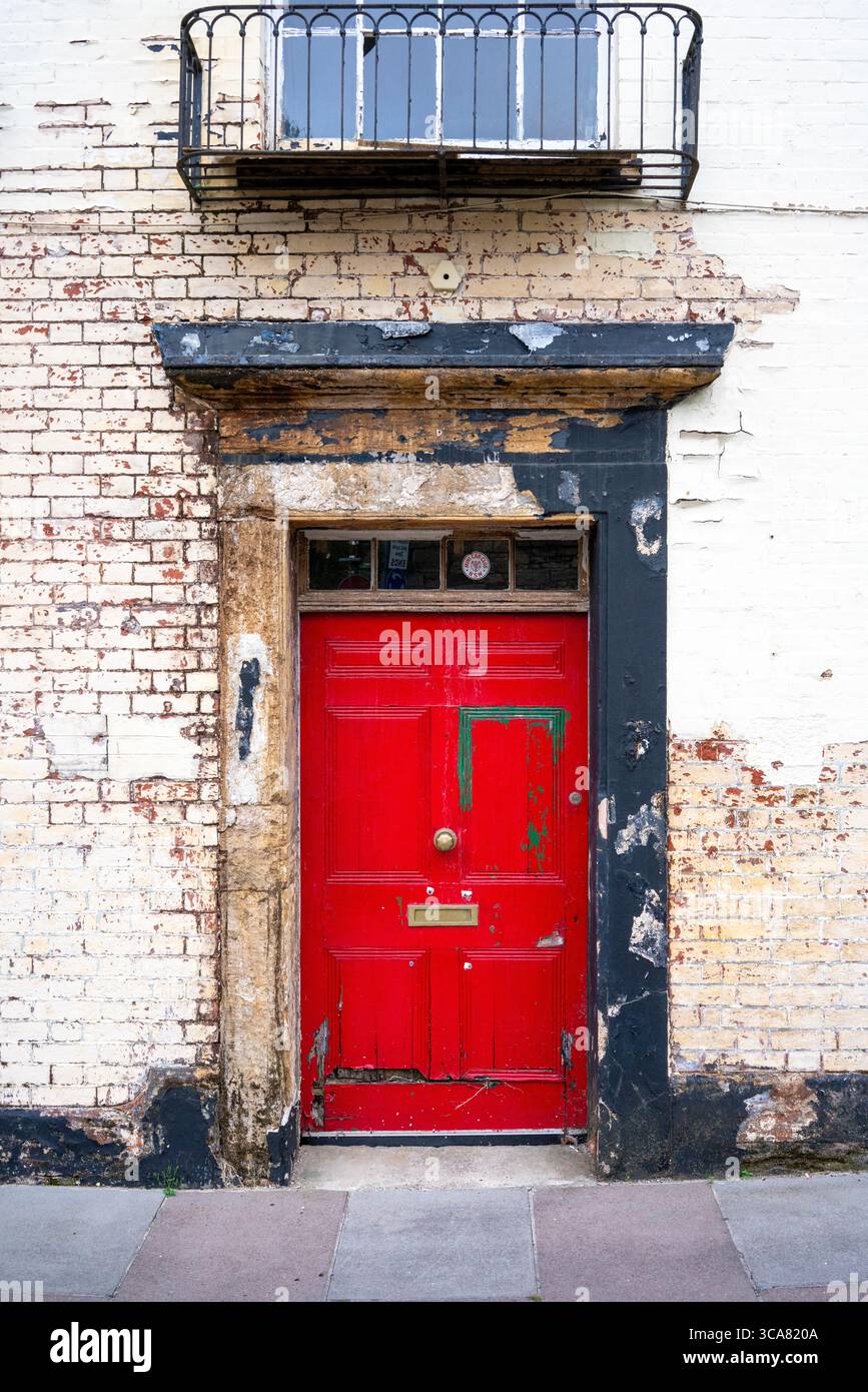 Porta rossa malandata e intemprata Foto Stock