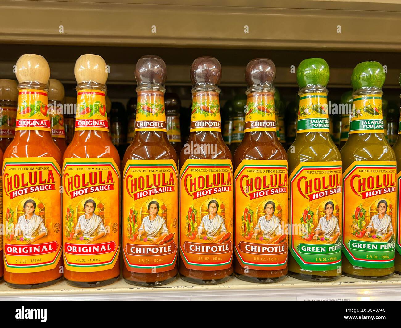 Varietà di bottiglie di salsa calda Cholula sullo scaffale di un supermercato. Utah, Stati Uniti. Foto Stock