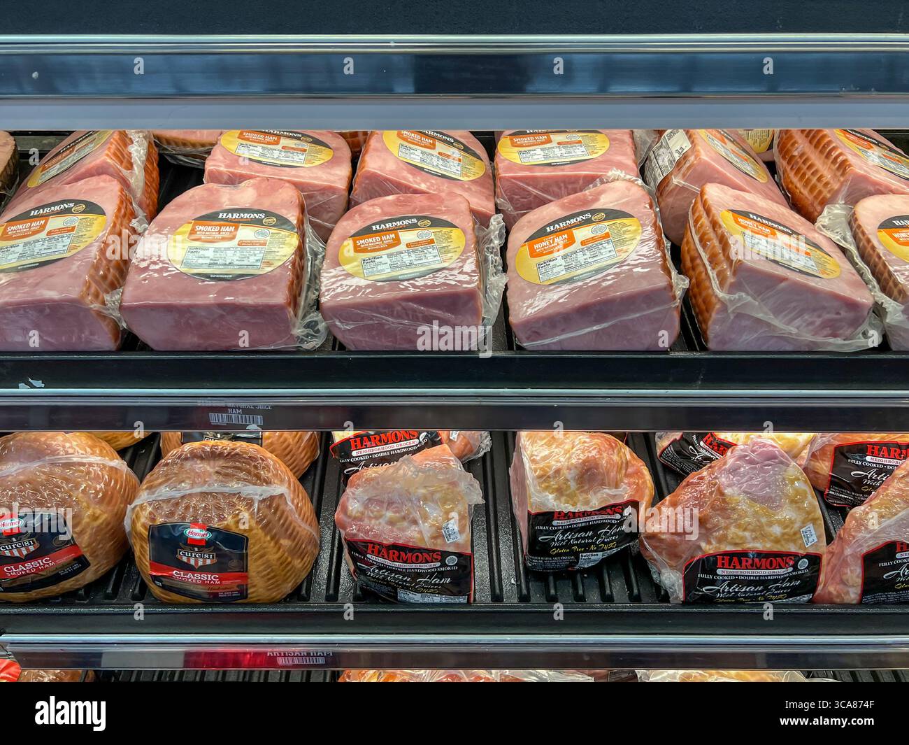 Varietà di prosciutti in congelatore da esposizione per la vendita in un supermercato. Utah, Stati Uniti. Foto Stock
