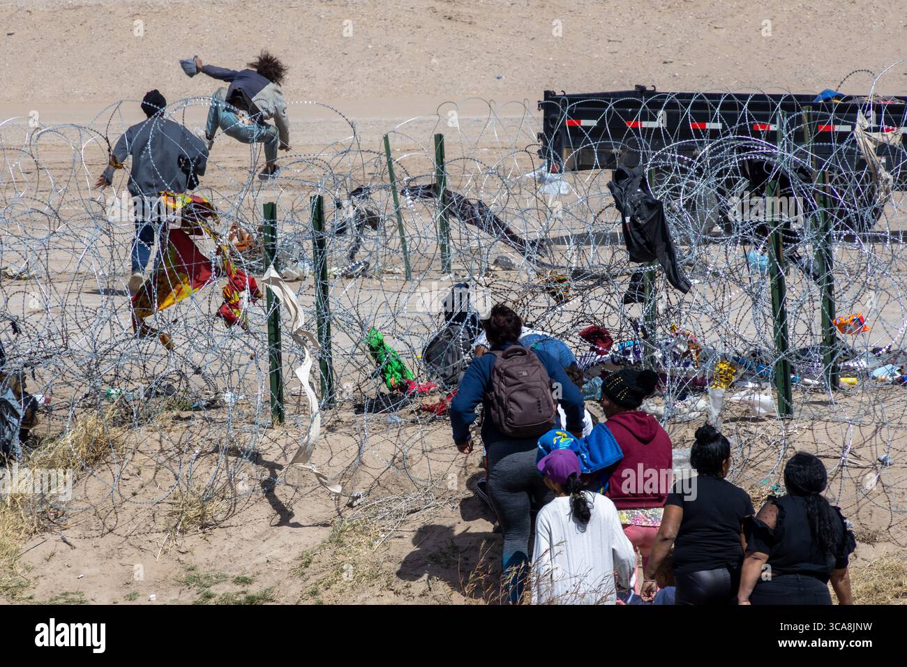 Le famiglie navigano sul filo di concertina al confine di Ciudad Juarez. Foto Stock
