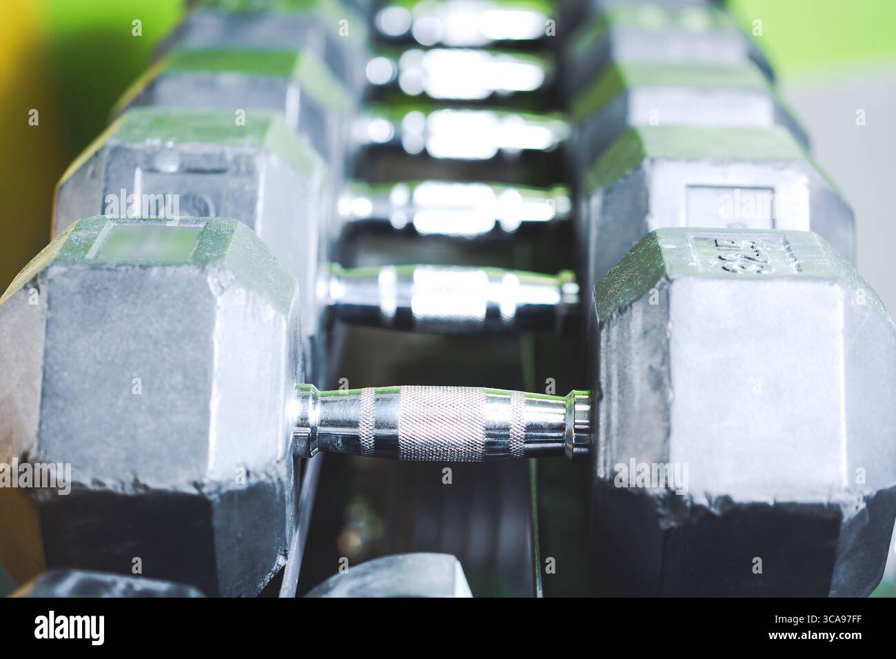 Concetto di sport fitness. Set di manubri neri. Avvicinati a molti manubri in metallo sul rack nel centro fitness sportivo. Messa a fuoco selettiva Foto Stock