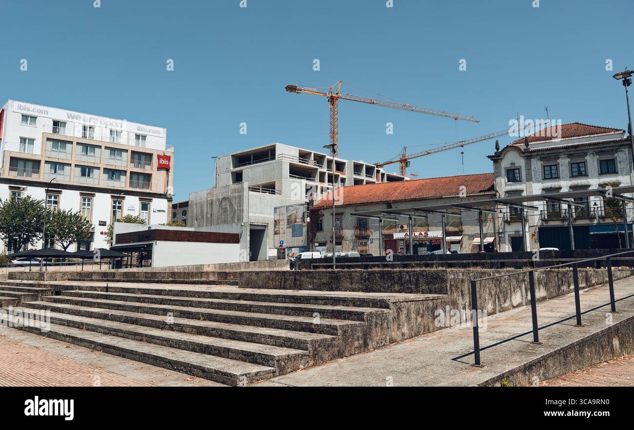 In corso di sviluppo urbano a Braga, le gru sorgono dietro le facciate storiche e le moderne catene alberghiere vicino al centro della città Foto Stock
