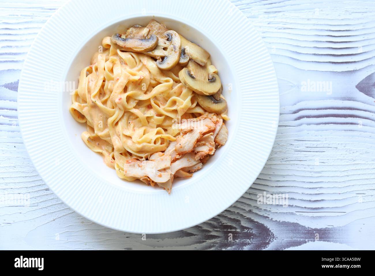 Primo piano con funghi cremosi e pollo alle tagliatelle italiane mediterranee Foto Stock