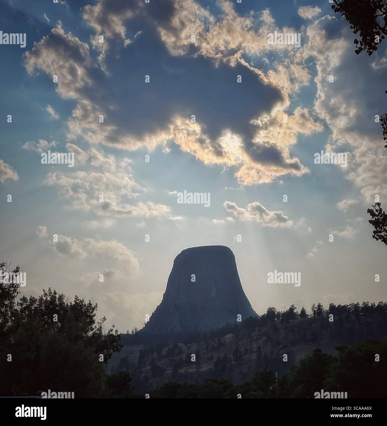 Immagine spettacolare del Monumento Nazionale della Torre del Diavolo sotto un cielo pieno di nuvole e raggi del sole che si infrangono. Foto Stock