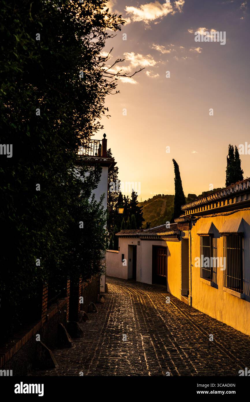 Golden Sunset illumina una tranquilla strada acciottolata in un villaggio mediterraneo Foto Stock