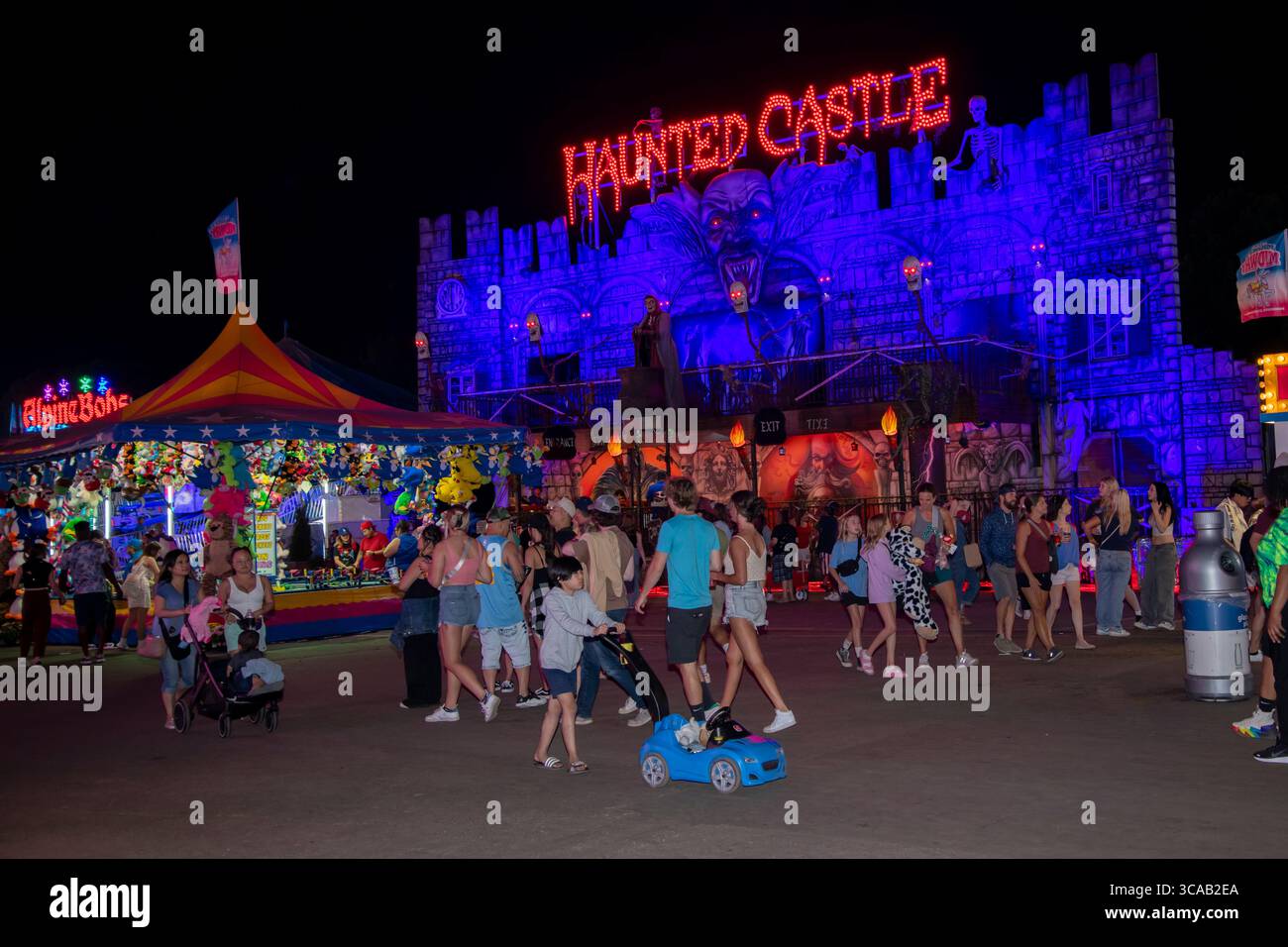 Falcon Heights, Minnesota. Fiera dello stato del Minnesota. Persone che camminano di fronte al Castello infestato di notte a metà strada. Foto Stock