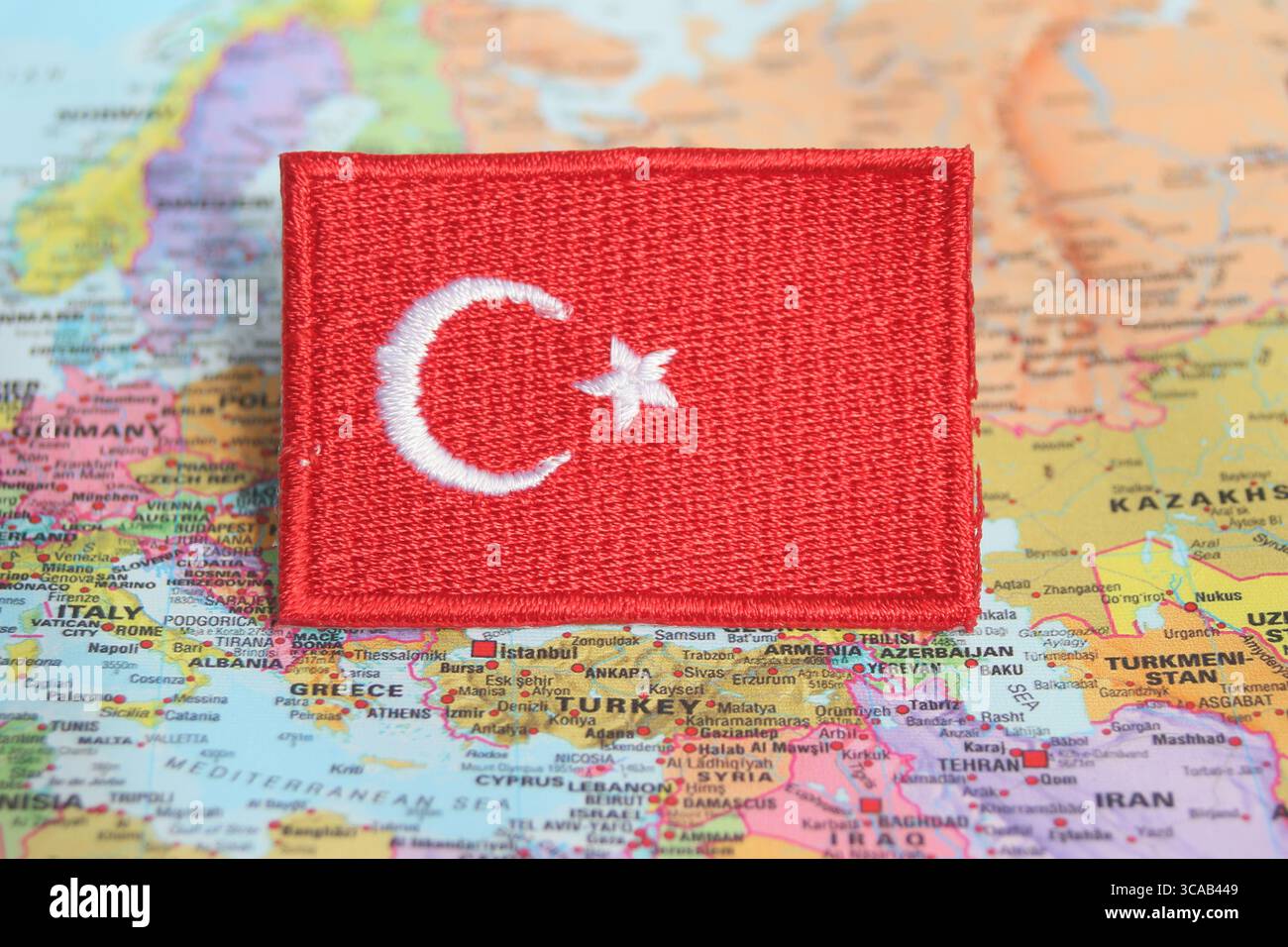 La bandiera turca ricamata è collocata su una mappa del mondo nella località della Turchia, simboleggiando viaggi, patriottismo e turismo ecosostenibile. Foto Stock