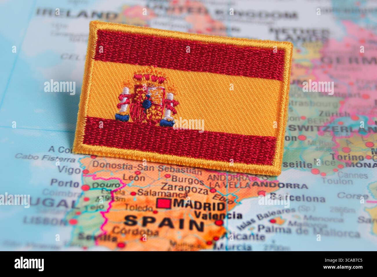 Bandiera spagnola ricamata su una mappa mondiale della Spagna, simboleggia il patriottismo, l'ispirazione per i viaggi e le esperienze turistiche ecocompatibili. Foto Stock