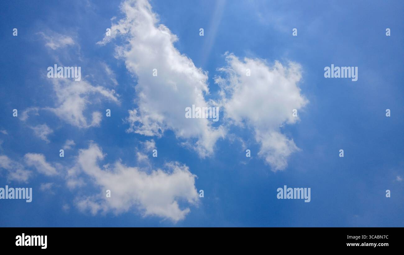 Cielo blu brillante con soffici nuvole bianche in un giorno di sole Foto Stock