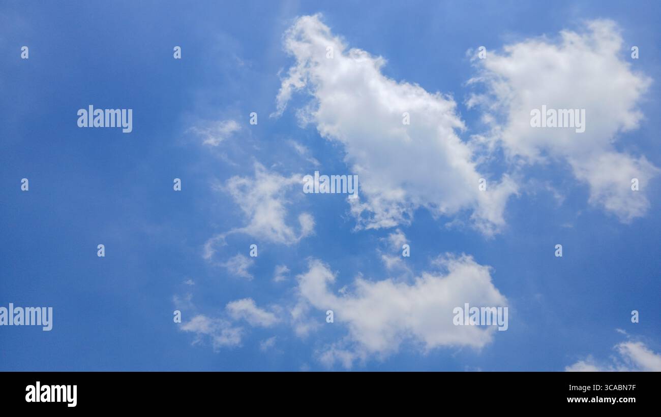 Cielo blu brillante con soffici nuvole bianche in un giorno di sole Foto Stock