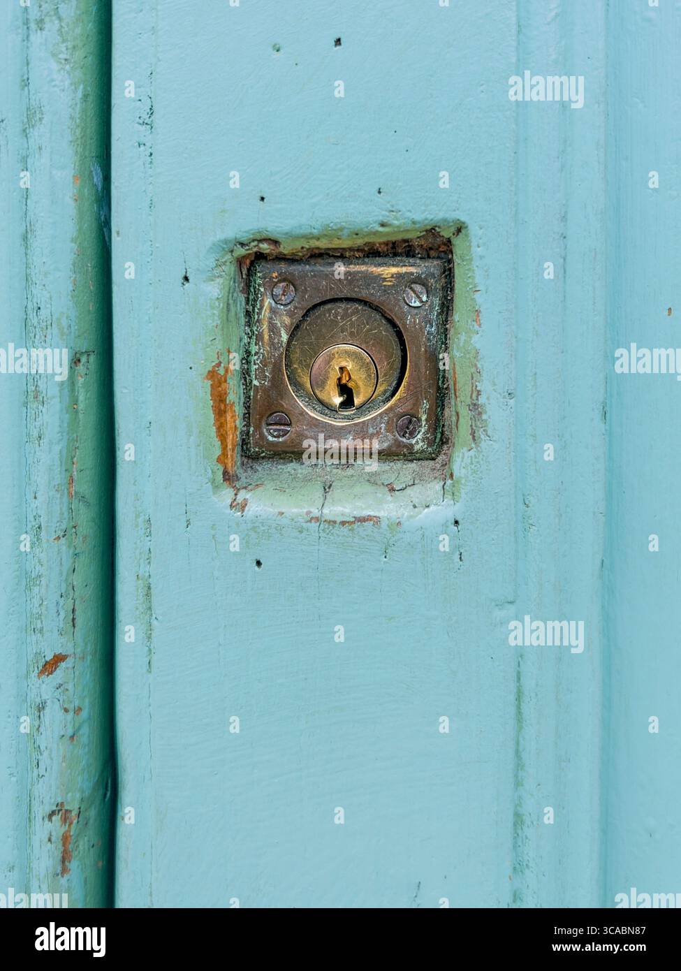 Serratura in ottone vecchio e usurato sulla porta blu ciano antico, chiusura della serratura, copia dello spazio Foto Stock