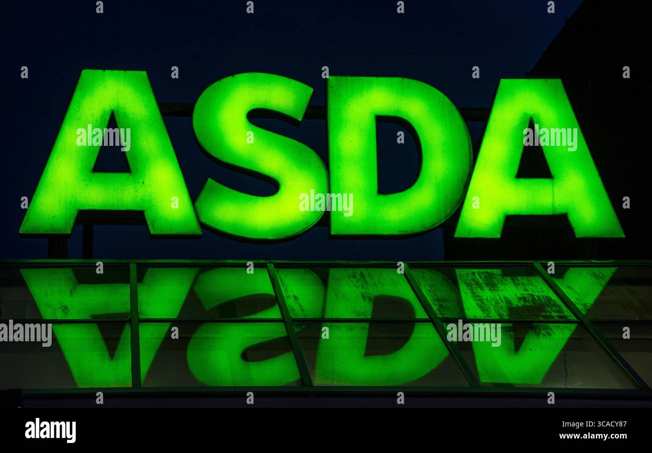 Famoso negozio di alimentari del marchio britannico, logo ASDA con riflesso nel vetro Foto Stock