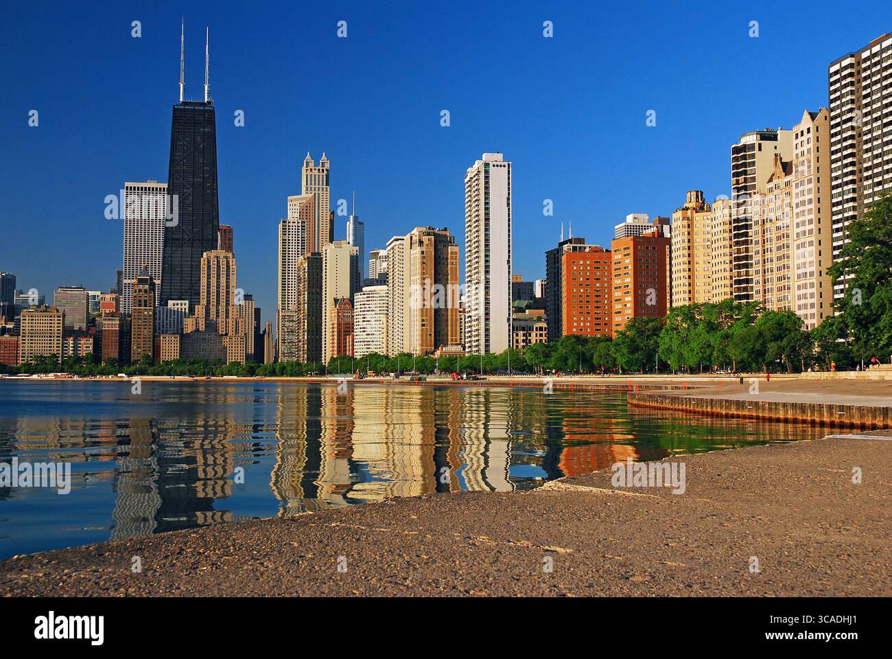 Lo skyline della città di Chicago si riflette nelle acque tranquille del lago Michigan Foto Stock