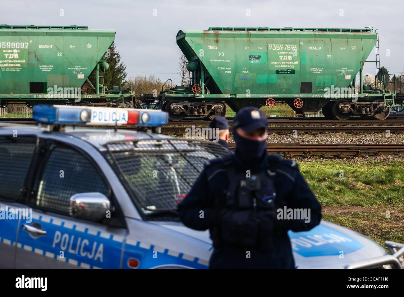 16 aprile 2023, Hrubieszow, Polonia: I carri delle tramogge di grano dell'Ucraina passano mentre la polizia sta sorvegliando la protesta degli agricoltori in corso vicino al valico di frontiera polacco-ucraino a Hrubieszow, Polonia, il 16 aprile 2023. Gli agricoltori polacchi protestano contro le importazioni di prodotti agricoli ucraini, che invece di essere trasportati attraverso la Polonia verso i paesi di destinazione, rimangono nel paese e inondano il mercato. Gli agricoltori comprendono una situazione difficile causata dall'invasione russa in Ucraina, ma sollecitano il governo polacco a regolamentare le importazioni. Il governo polacco ha annunciato il divieto Foto Stock