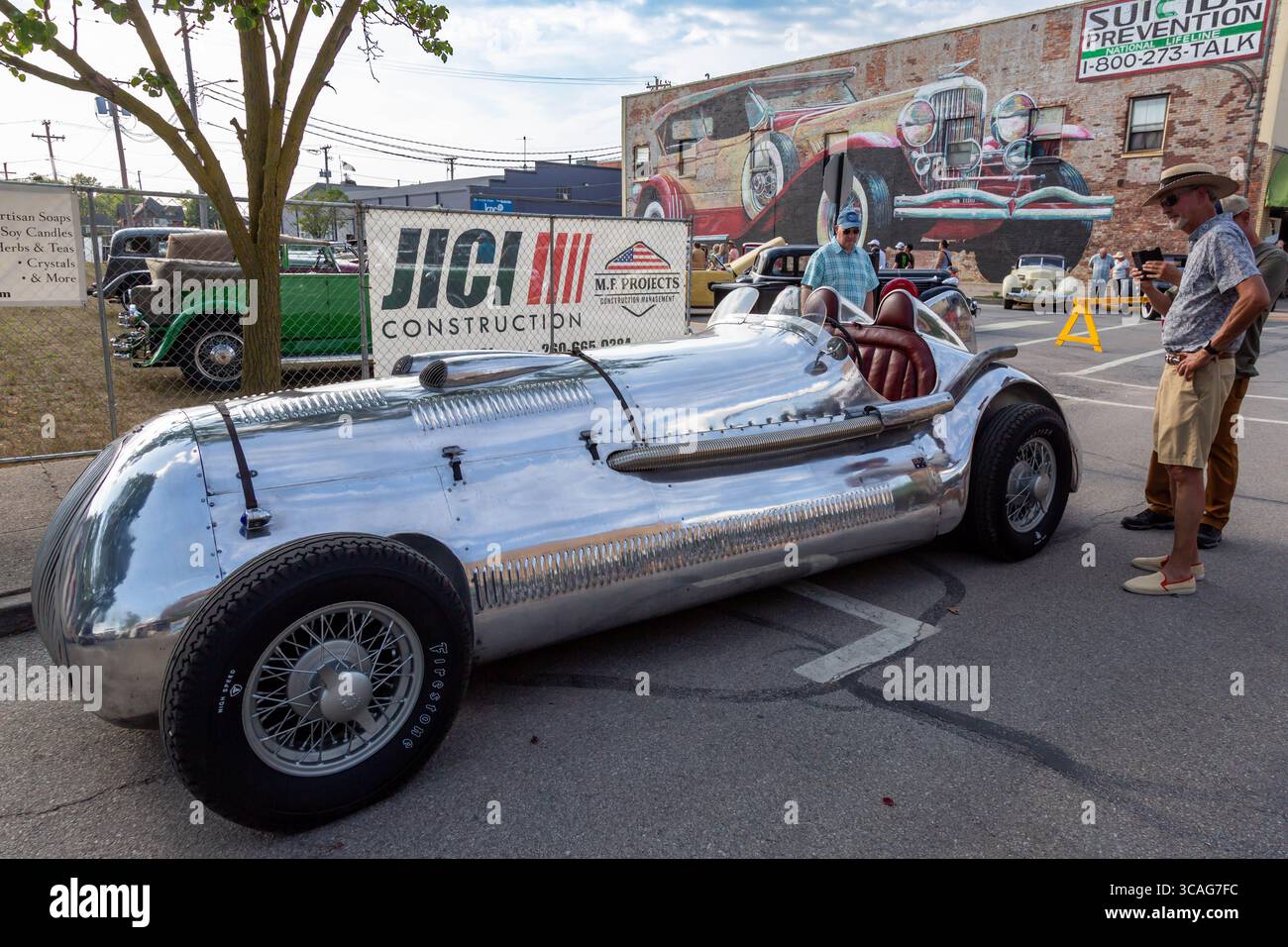 Gli uomini ispezionano l'esclusiva auto sportiva G. Bigata Douze Special del 1932 in mostra ad un'esposizione di auto ad Auburn, Indiana, USA. Foto Stock