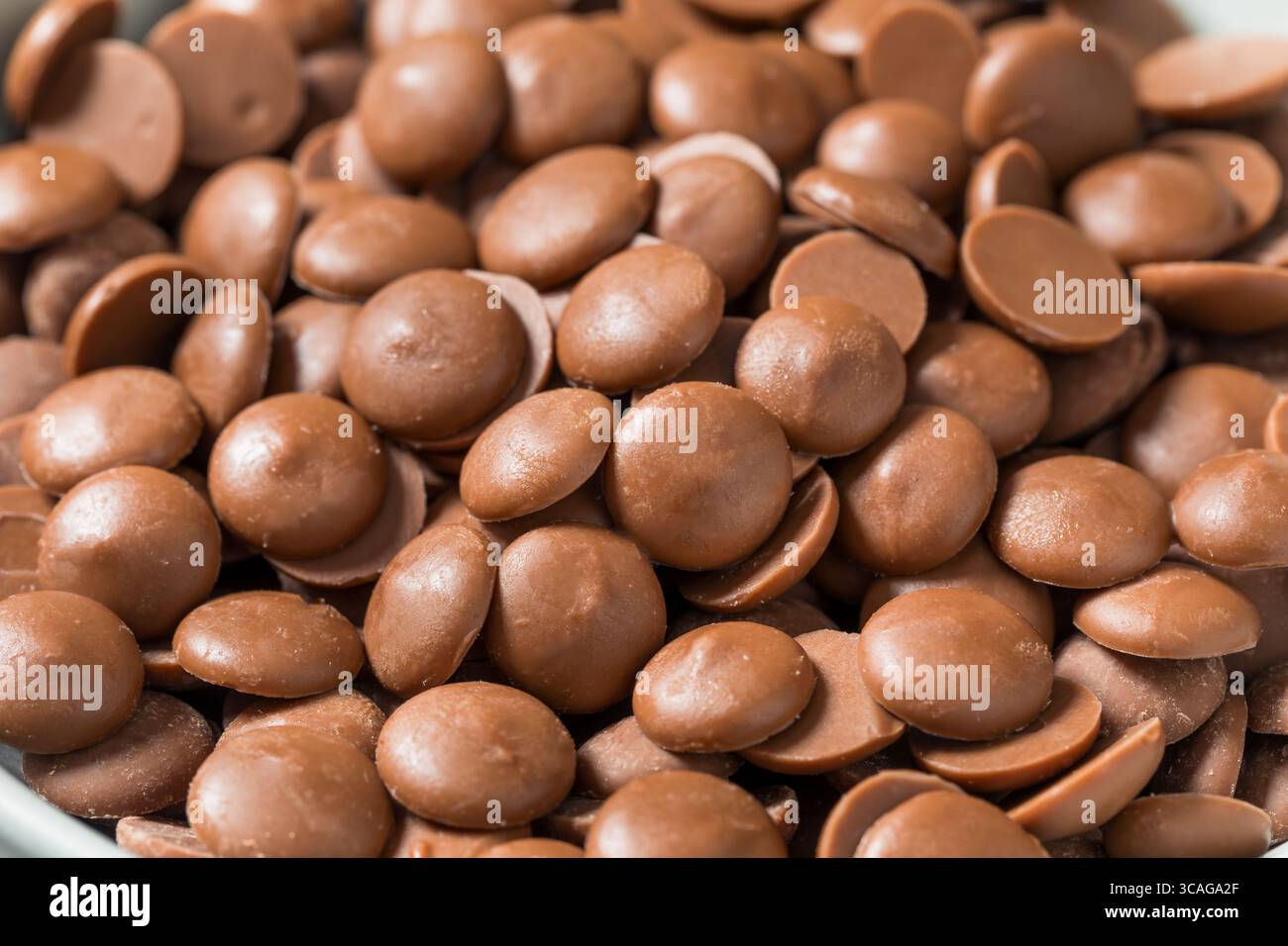 Scaglie di cioccolato al latte crudo biologico da cuocere in una ciotola Foto Stock