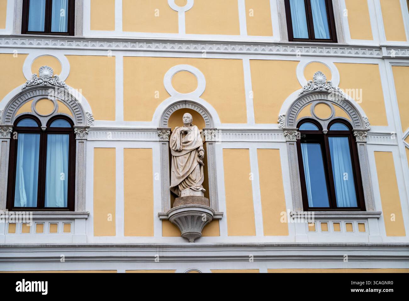 La Casa Rusconi di Trieste, in stile rinascimentale veneziano, presenta elementi decorativi intorno alle finestre con frontoni ad arco e una statua in una nicchia. Foto Stock