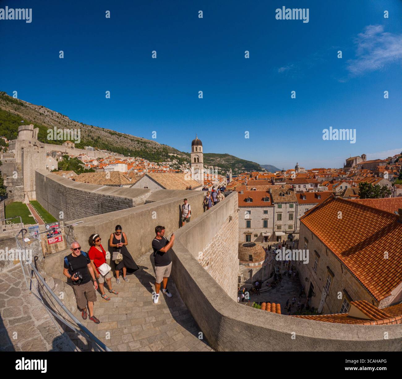 Dubrovnik, Croazia - 14 settembre 2023: I turisti esplorano le storiche mura della città, scattando foto e ammirando le vedute panoramiche della città vecchia. Foto Stock