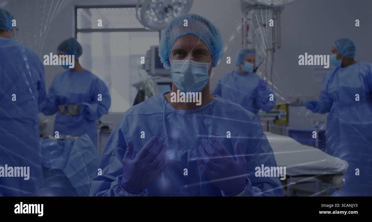 Fotocamera di fronte chirurgo asiatico in scrub blu guanti di regolazione in sala operatoria, con luci a soffitto Foto Stock
