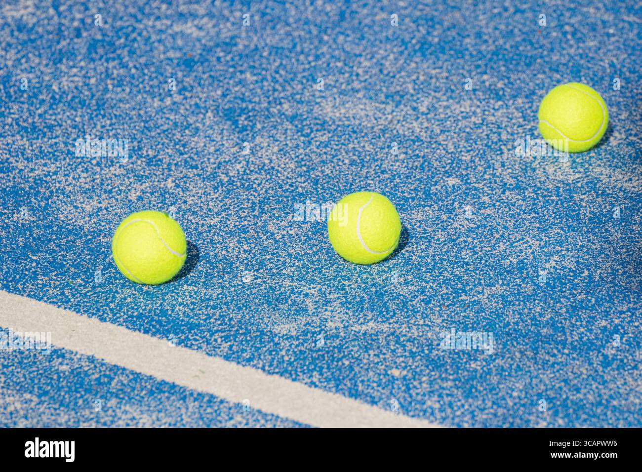 Campo in padel blu con linee bianche e palle gialle di fondo sportivo Foto Stock