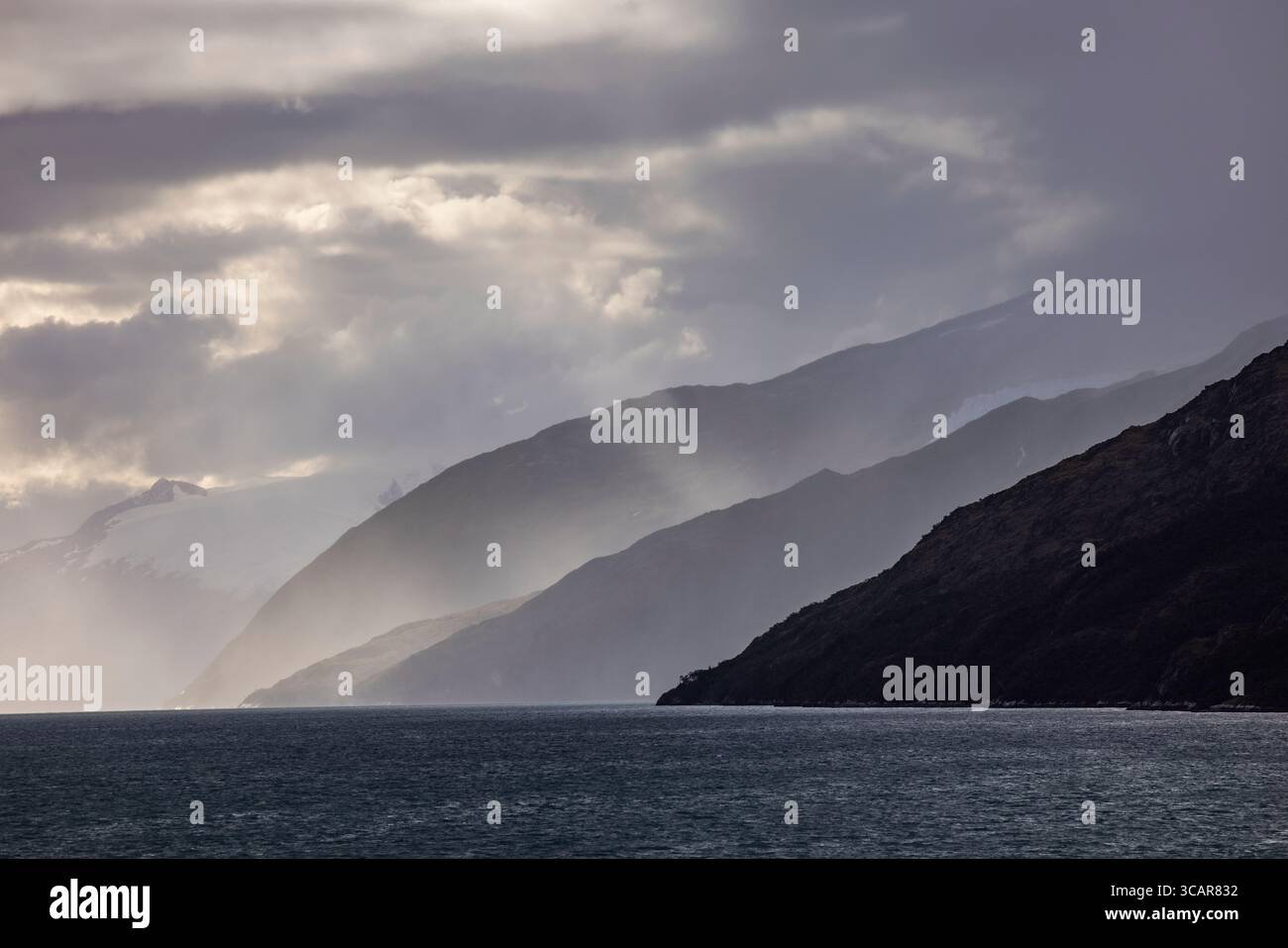 Nuvole e luci spettacolari con montagne viste dalla nave da crociera Ventus Australis (Australis Cruises) durante il passaggio della "Ave Foto Stock