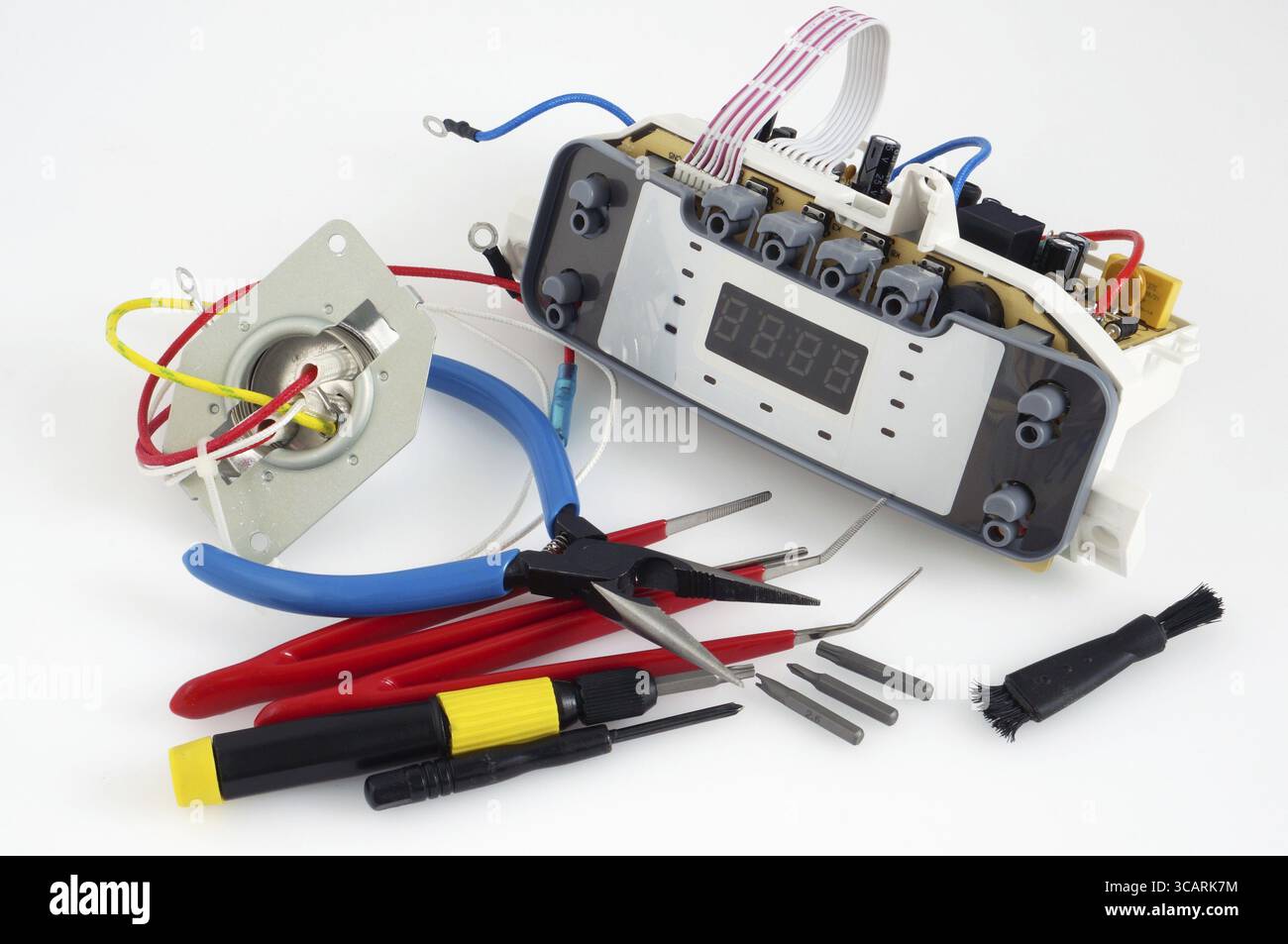 I pezzi di ricambio e gli utensili elettronici sono collocati sul tavolo di riparazione MAN White del centro di assistenza. Produzione di massa. Ripresa in studio Foto Stock