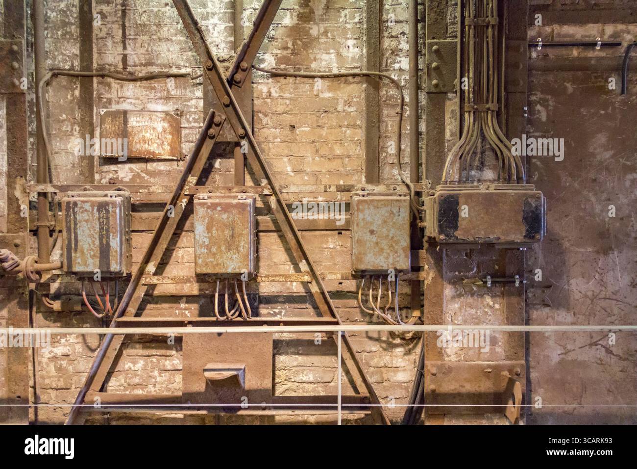 Dettagli industriali arrugginiti agli agenti atmosferici, tra cui vecchi armadi di controllo elettrici corrosi Foto Stock