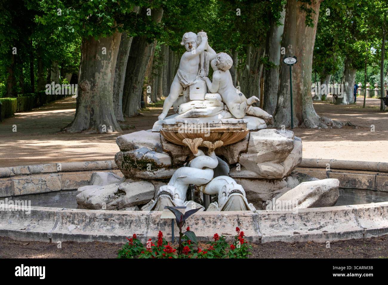 22 maggio 2022, Madrid, Spagna: Giardino dell'isola nei Giardini reali spagnoli, giardino del Parterre, Aranjuez, Spagna. Sala dei monarchi cattolici. Fontana della Boticaria all'inizio del Paseo de los Reyes CatÃ³licos. Nel 1777, sotto il regno di Carlo III, fu costruita una diga sul Tago lunga oltre 300 metri, sormontata da una ringhiera di ferro tra i piedistalli con vasi. Questo ha creato un ampio spazio che è stato trasformato in una passeggiata con la piantagione di diverse file di banani. All'inizio della passeggiata, entrando nel giardino attraverso il ponte orientale, la fontana del Boticaro Foto Stock