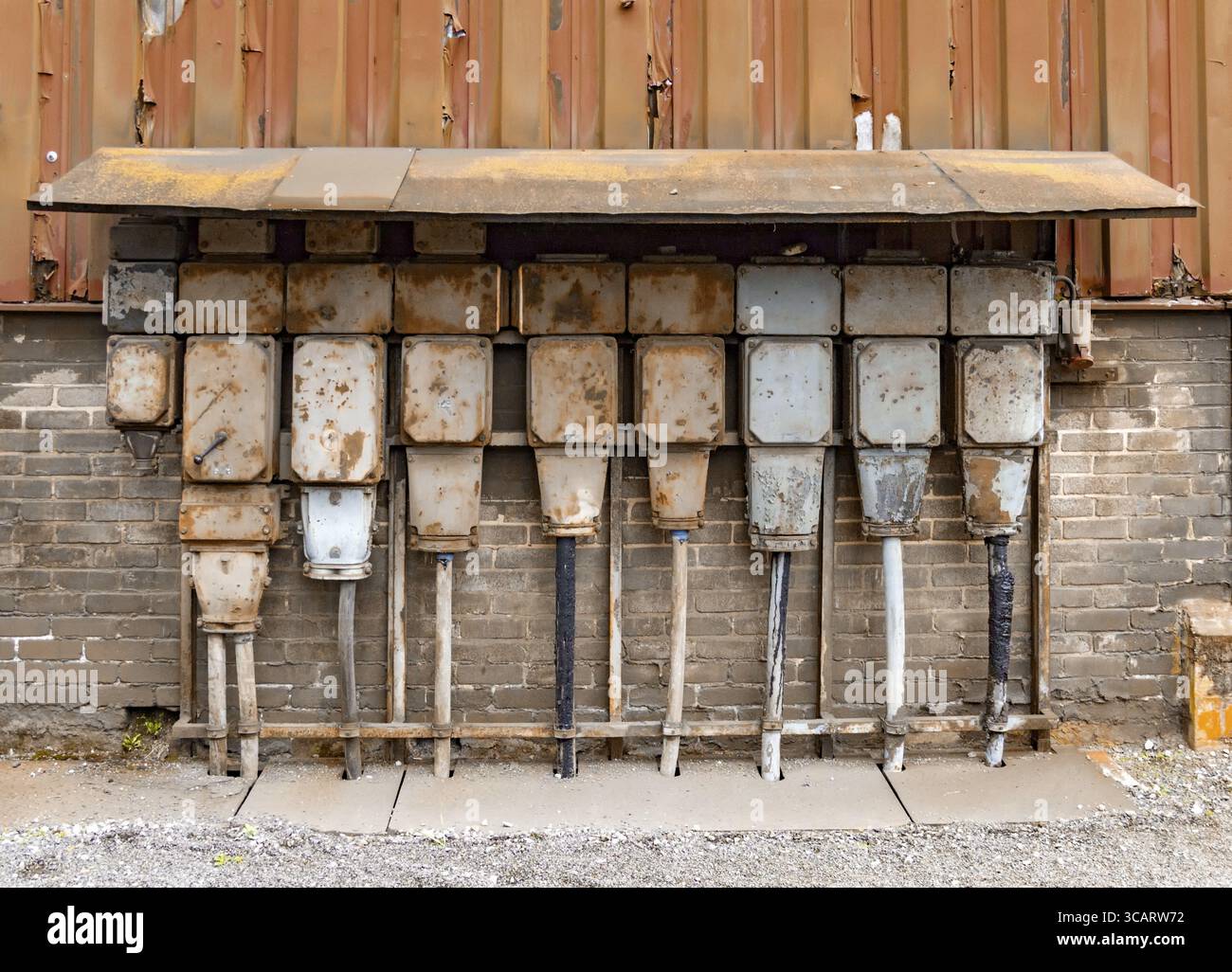 Dettagli industriali arrugginiti agli agenti atmosferici, tra cui vecchi armadi di controllo elettrici corrosi Foto Stock