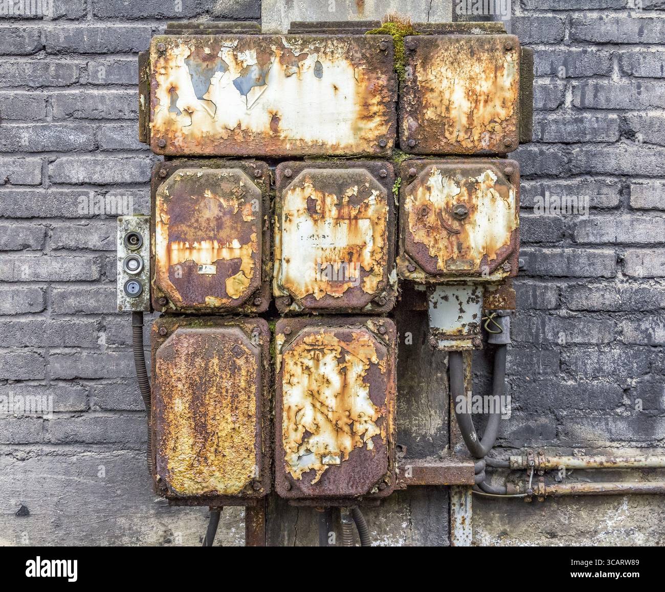 Dettaglio industriale arrugginito dagli agenti atmosferici che mostra un vecchio armadio di controllo elettrico corroso Foto Stock