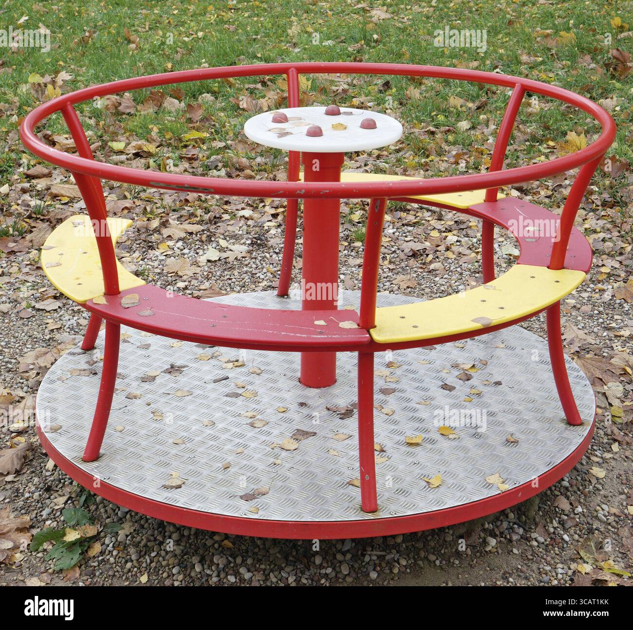 Una giostra per bambini sul parco giochi è realizzata in metallo, plastica e legno. Scatto all'aperto Golden Autunno nuvoloso Foto Stock