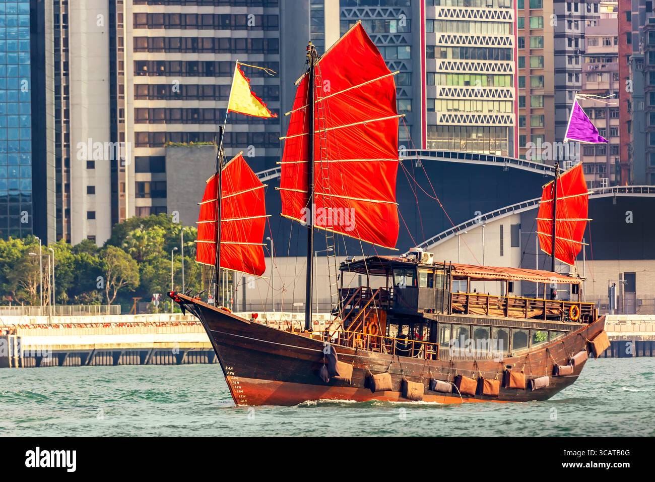 Vecchio traghetto turistico in legno nel porto di Victoria e vista sul famoso grattacielo dell'isola di Hong Kong. Foto Stock