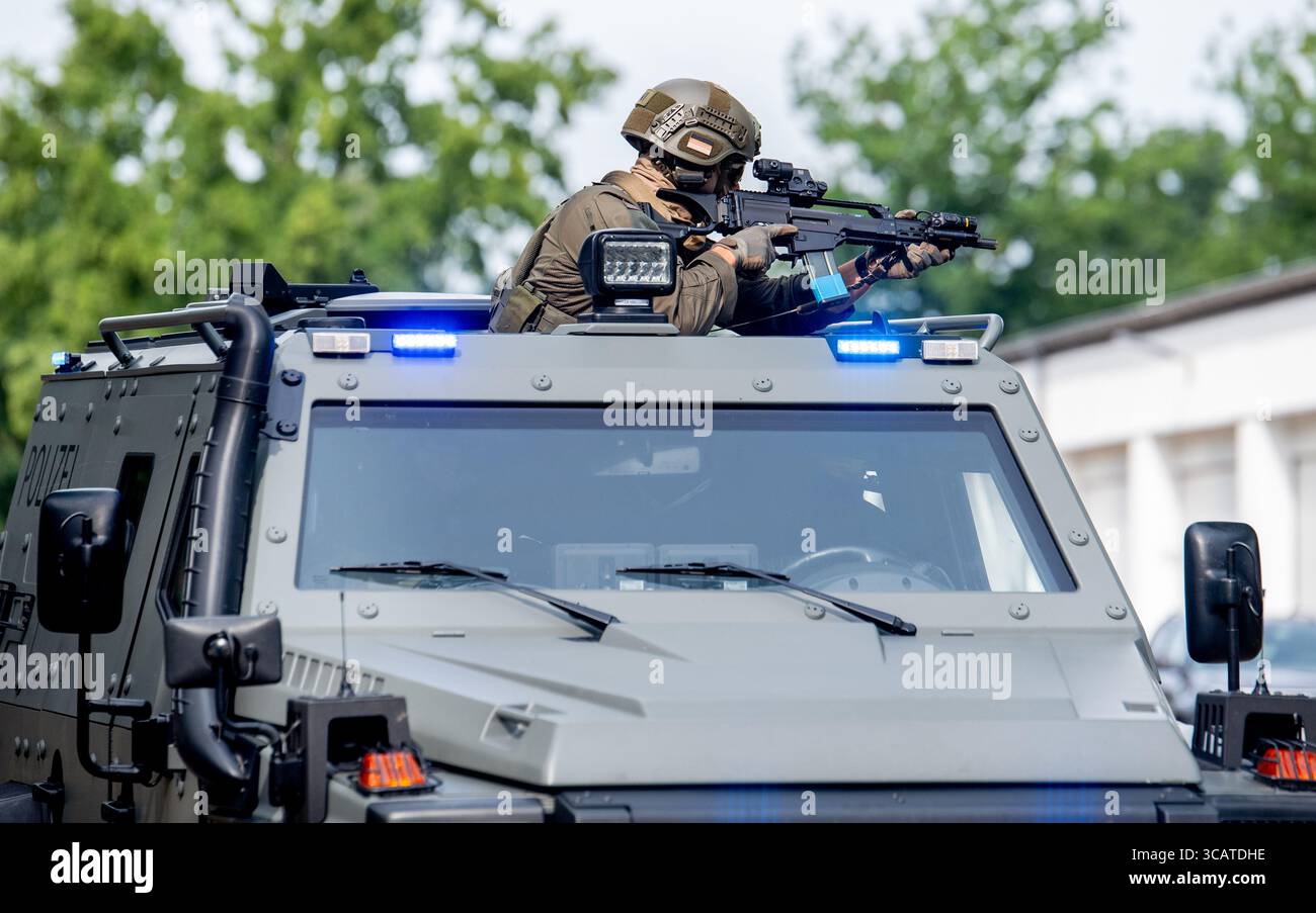 Oldenburg, Germania. 7 agosto 2025. Le forze speciali del comando operazioni speciali della bassa Sassonia circondano un edificio sul terreno dell'Accademia di polizia della bassa Sassonia con un veicolo blindato come parte di un'esercitazione per effettuare un arresto. Le unità speciali della polizia di stato esistono nella bassa Sassonia da 50 anni. La task force speciale (SEK) e la task force mobile (MEK) sono schierate quando sussiste una particolare minaccia o sono richieste conoscenze specializzate. Crediti: Hauke-Christian Dittrich/dpa/Alamy Live News Foto Stock