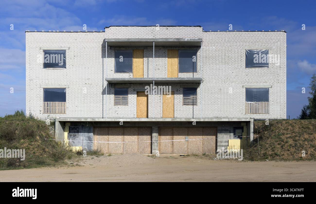 L'incompiuta abbandonato casa rurale da mattoni bianchi sulla collina di erba. Nessun nome di produzione di massa Foto Stock