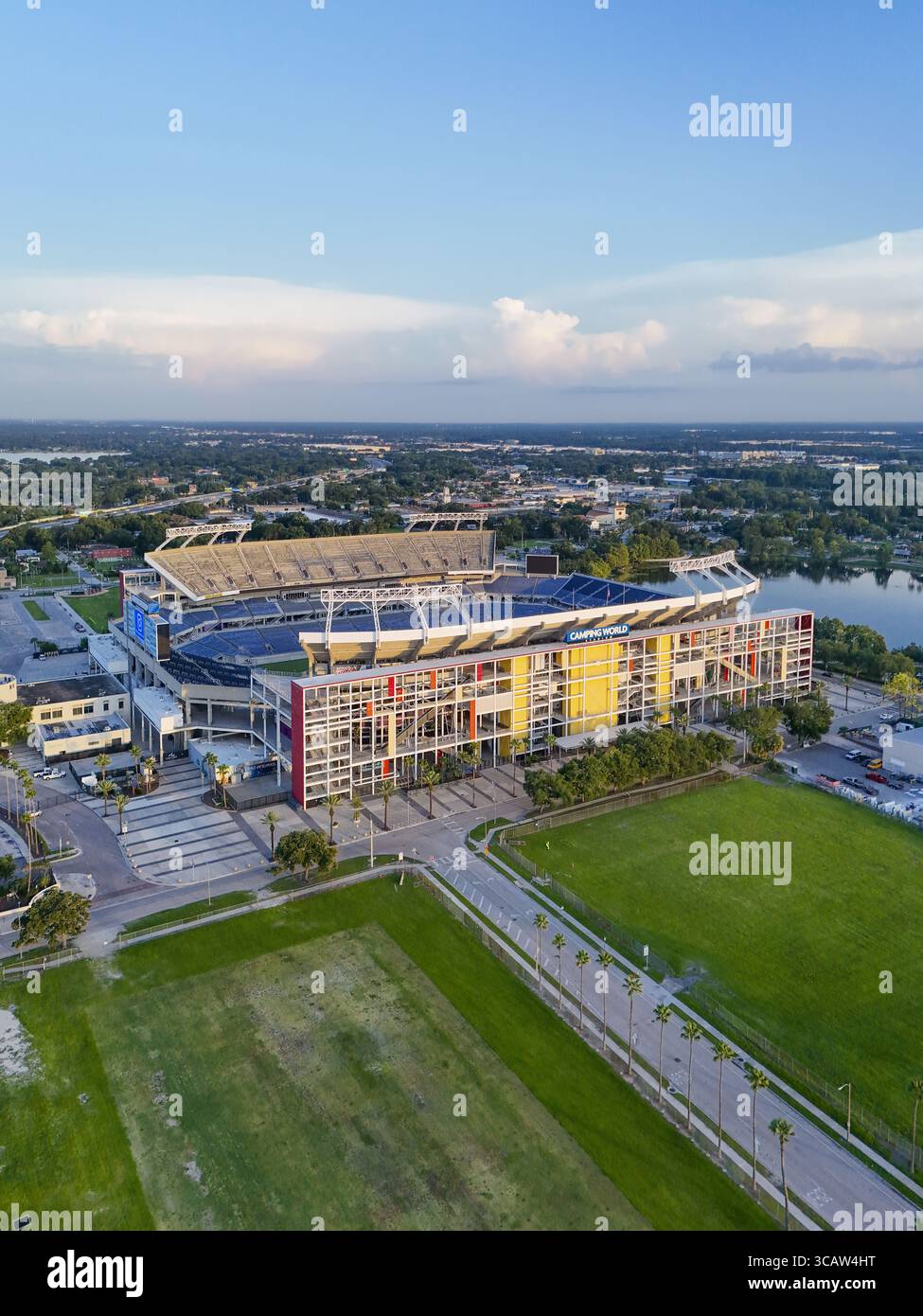 Orlando, Stati Uniti - 21 luglio 2025: Veduta aerea del Camping World Stadium si erge contro il cielo azzurro, circondato da un rigoglioso verde fiel Foto Stock