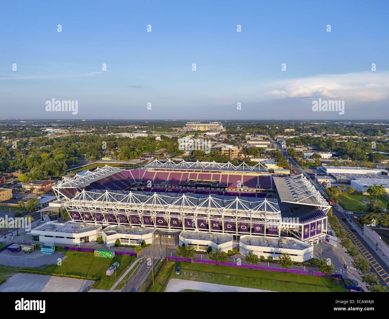 Orlando, Stati Uniti - 21 luglio 2025: Vista aerea del vibrante Camping World Stadium, con i suoi posti a sedere viola che si stagliano contro il verde paesaggio e il cielo blu. Foto Stock