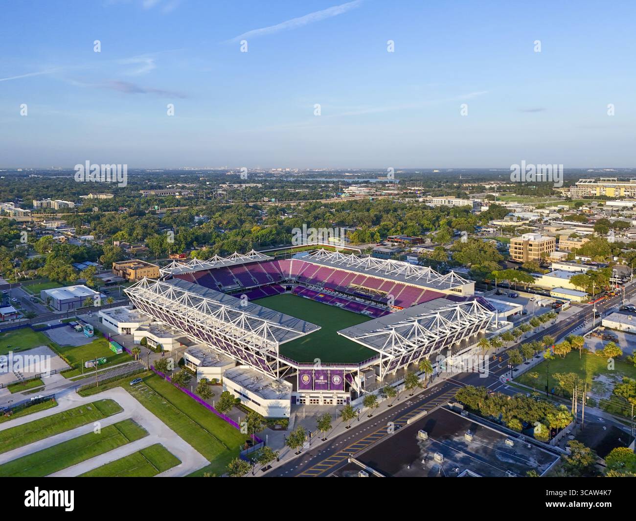 Orlando, Stati Uniti - 21 luglio 2025: Veduta aerea del Camping World Stadium, un vibrante spruzzo di viola e verde in mezzo alla proliferazione urbana, immersi nel verde Foto Stock