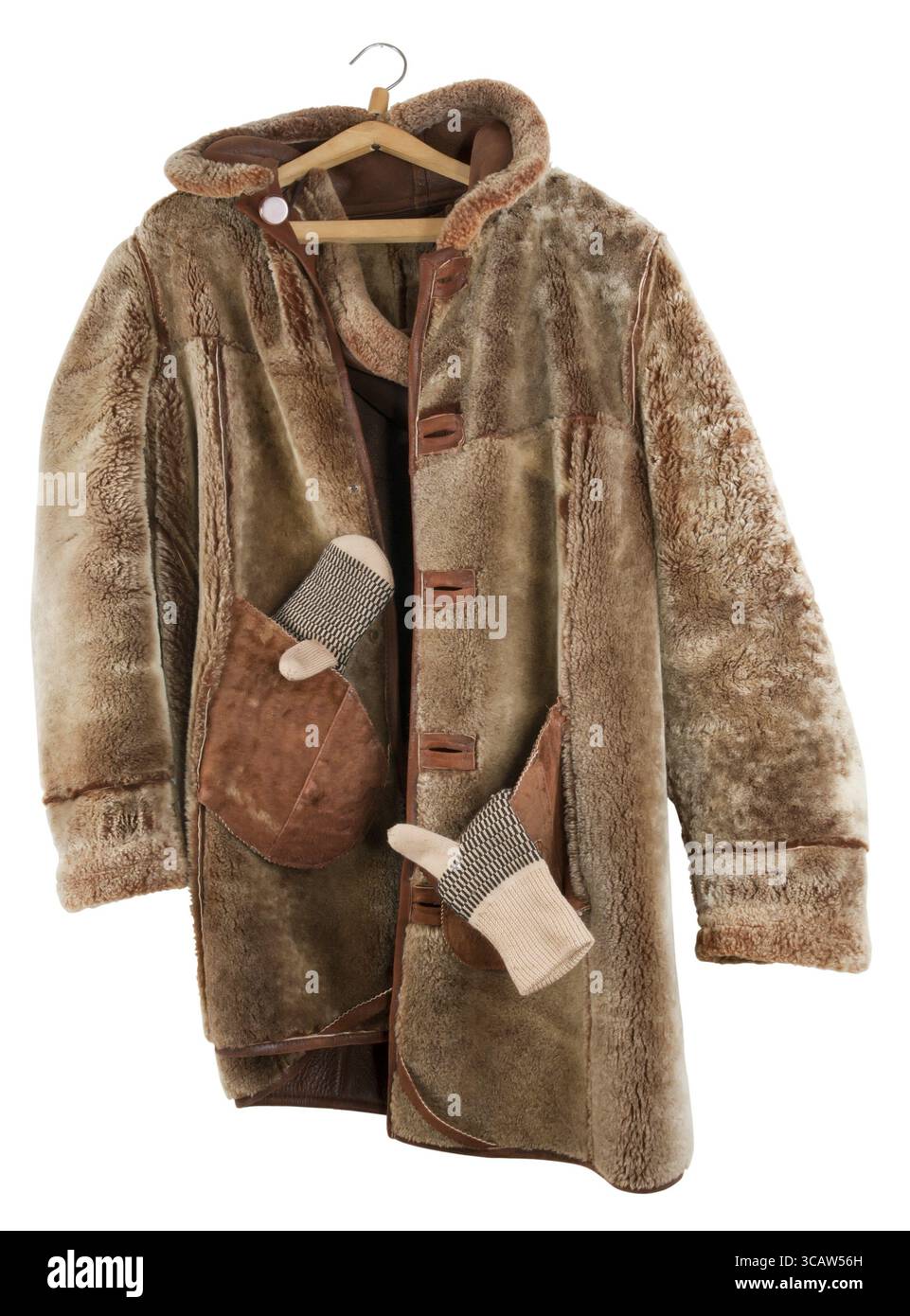 Il cappotto di pelliccia femminile viene ruotato all'interno verso l'esterno e appeso su un gancio. Isolata su una superficie bianca Foto Stock